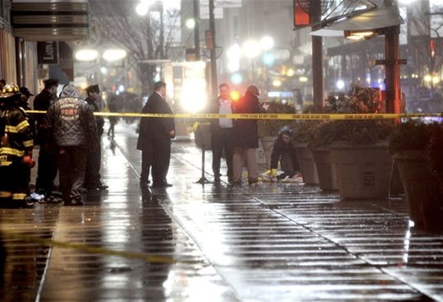 2esbjumper.jpg A medical examiner looks at the body.