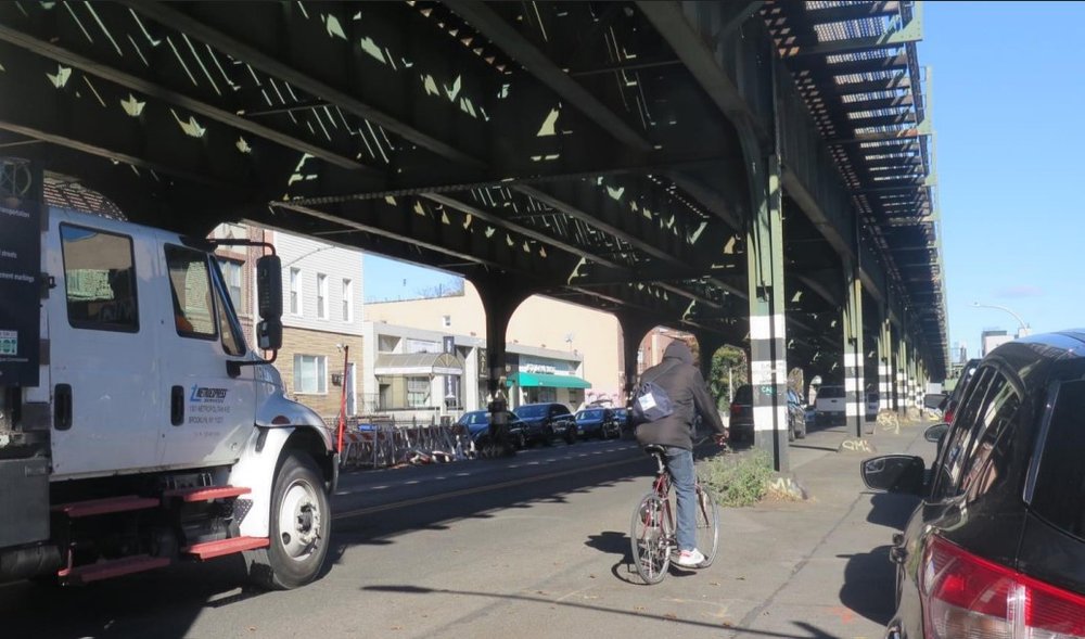 A road below elevated tracks.