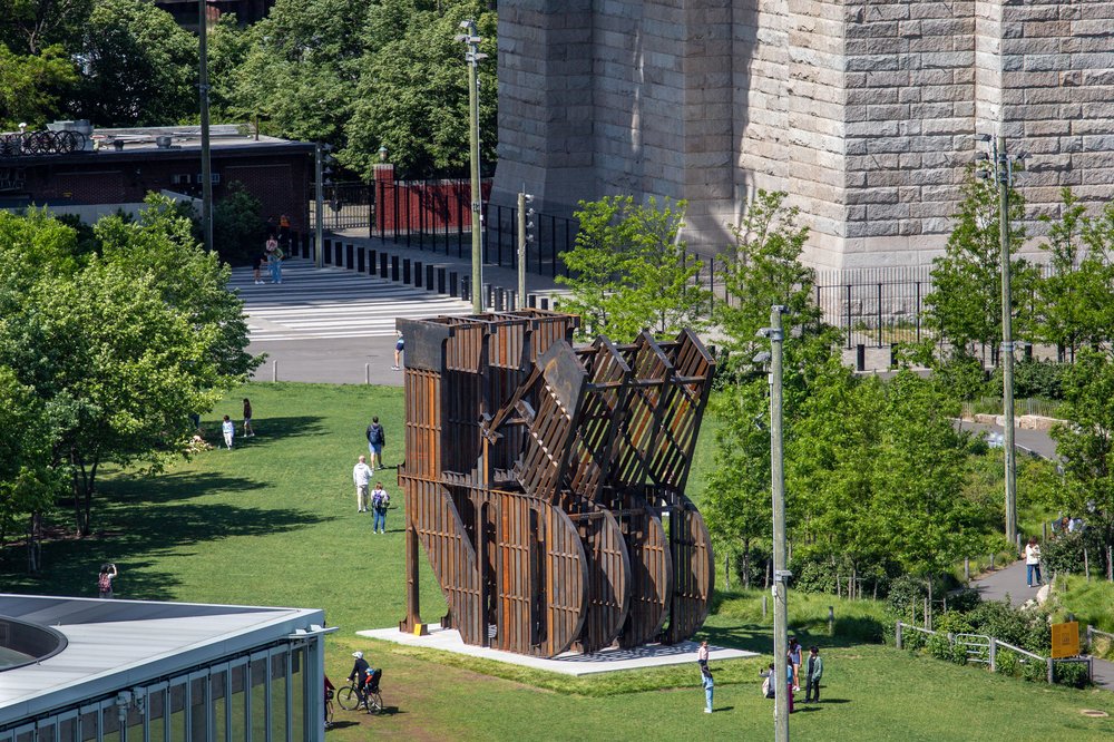 A large metal sculpture standing alongside the Brooklyn Bridge