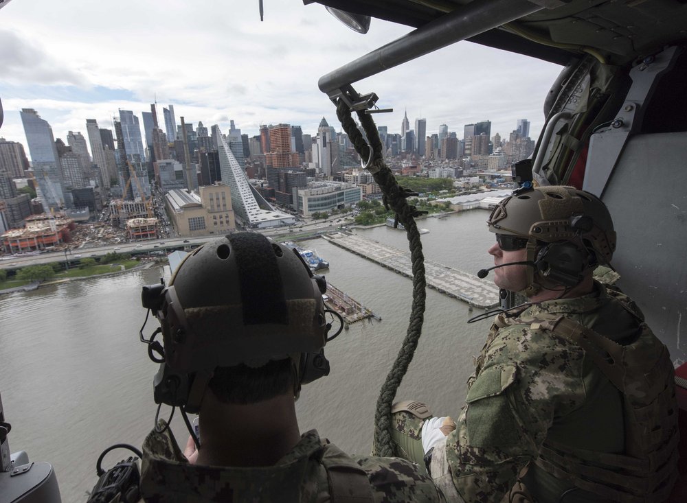 Explosive Ordnance Disposal Technicians assigned to Explosive Ordnance Disposal Group (EODGRU) 2, fly past the New York City skyline on a MH-60S Sea Hawk helicopter assigned to “The Night Dippers” of Helicopter Sea Combat Squadron (HSC) 5 as part of Fleet Week New York 2017. (U.S. Navy photo by Mass Communication Specialist 2nd Class Charles Oki)