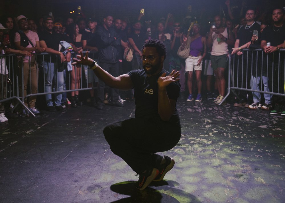 A person squats in dance move.