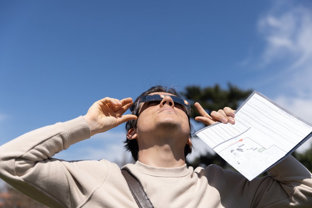 3M3A8694.jpg Rafael Araujo looks through eclipse glasses before the solar eclipse at Greenwood Cemetery in Brooklyn, New York on April 8, 2023.