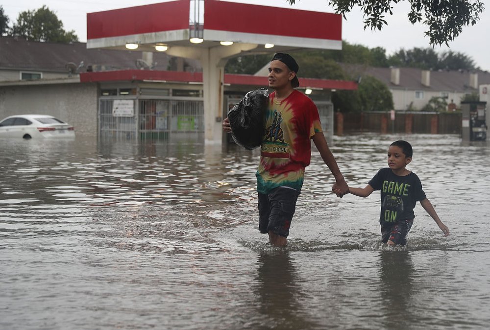 3d388a8c4gettyimages-839967898-jpg.jpeg People walk down a flooded street as they evacuate their homes after the area was inundated with flooding from Hurricane Harvey on August 27, 2017 in Houston<br>