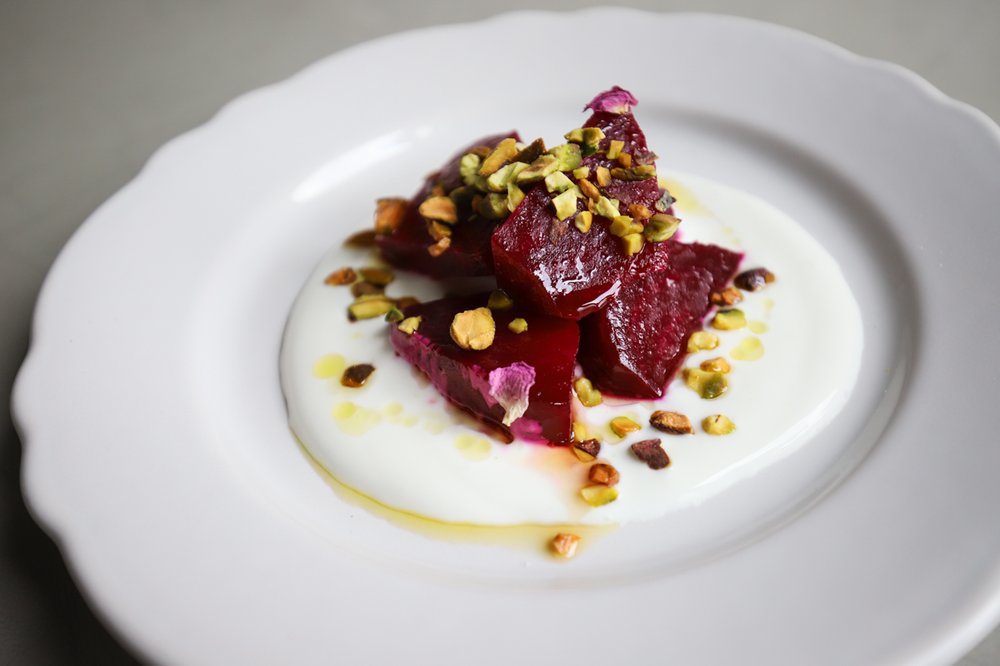 Honey Roasted Beets: strained housemade yogurt, olive oil, pistachio, herb roasted beets, garnished with Iranian rose petals<br/>