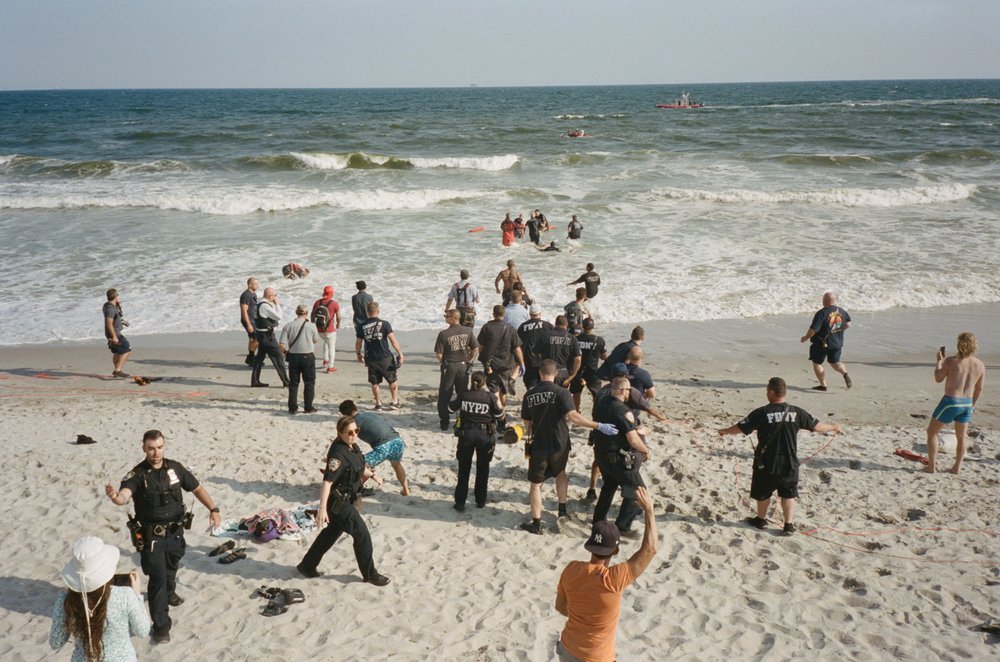 First responders rush to aid someone in the ocean.