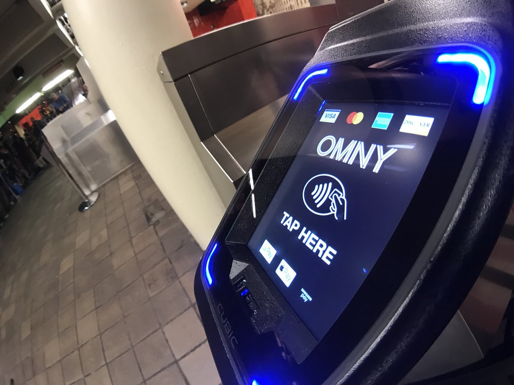 A close-up of the OMNY reader at a subway turnstile