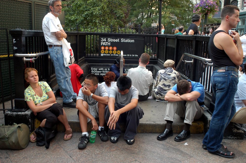 People sitting outside a closed subway station (Shutterstock)