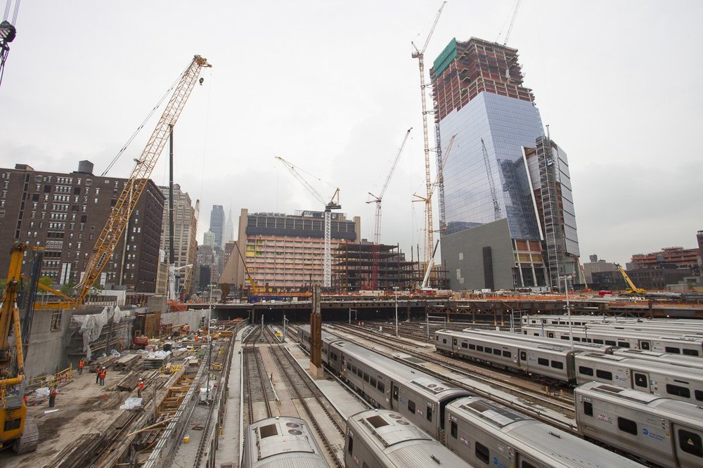 Here we're looking at the East Yard from 11th Avenue.  You can see the massive, nearly complete 10 Hudson Yards, which will house Coach, L'Oreal, SAP, and others.  To the left is "The Shops & Restaurants at Hudson Yards", a Time Warner Center style shopping experience with a big Neiman Marcus, other stores, and restaurants.   Soon the train tracks in the foreground will be covered up by the expanding deck.<br/>