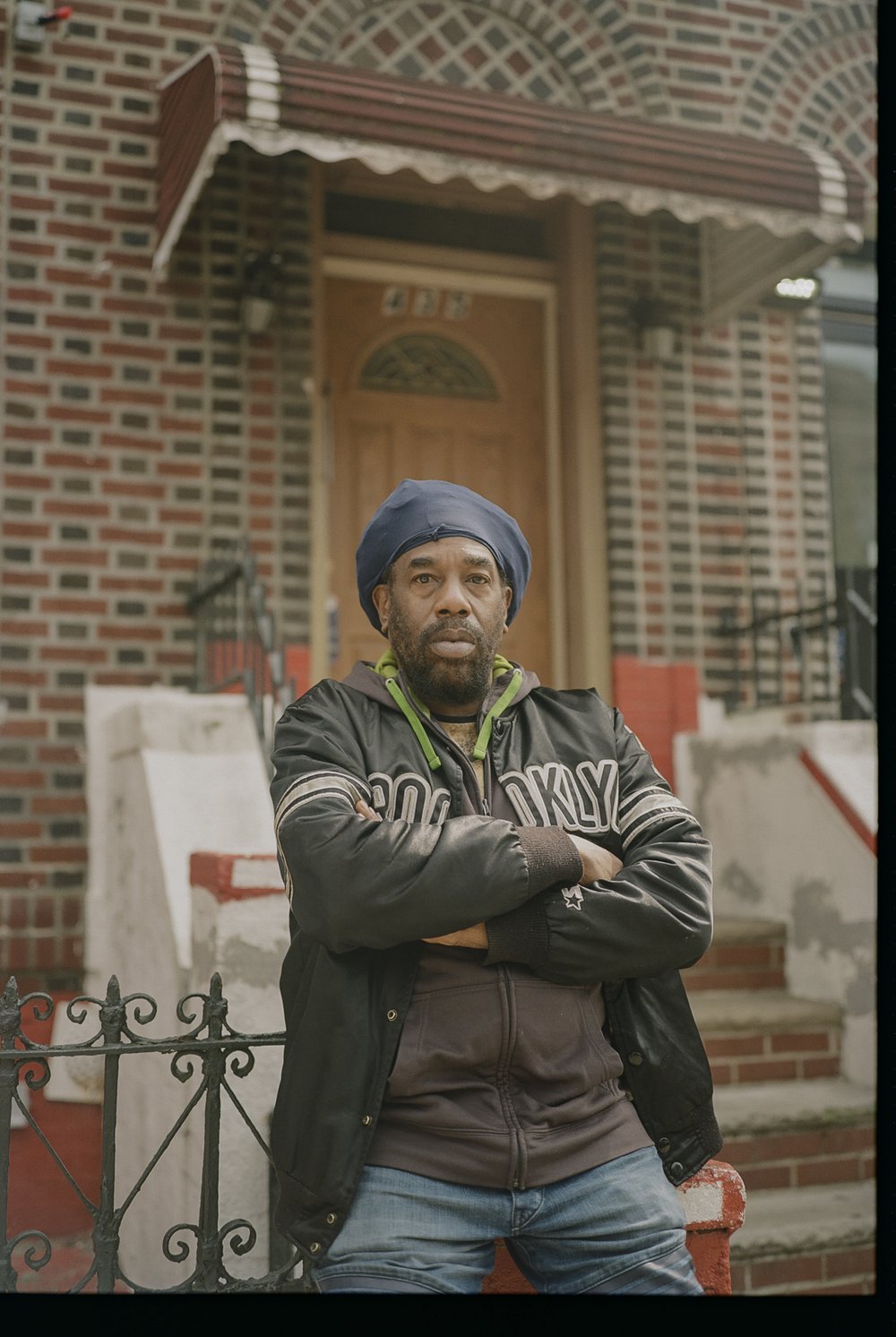 A man sits in front of a house.