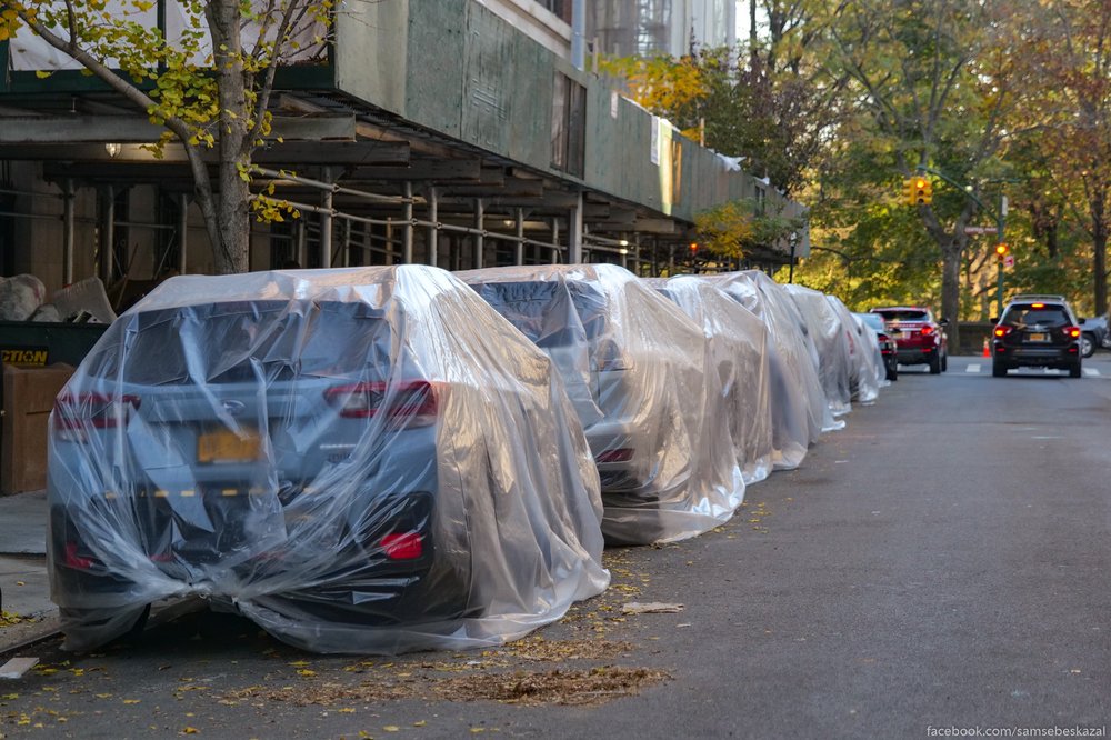 A photo of cars in plastic wrapping on sidewalk