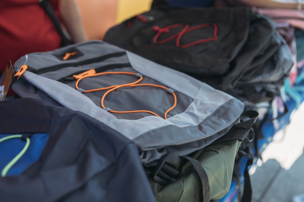Backpacks piled on a table.