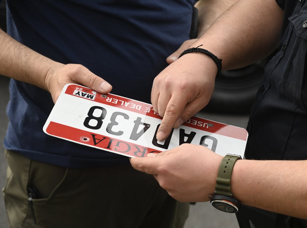 MTA police looking at an illegal license plate.