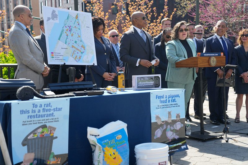 City officials, including Mayor Eric Adams and the newly minted Rat Czar, stand outside at a press conference showing posters about rat mitigation.