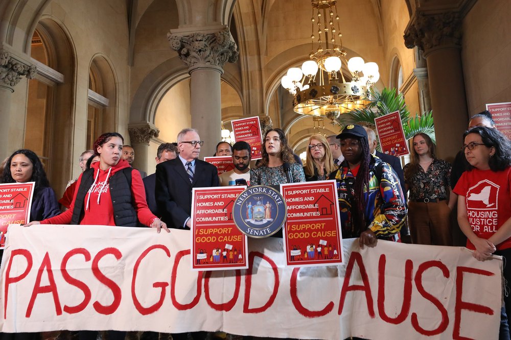 State Sen. Julia Salazar stands behind a banner saying "pass good cause" along with a handful of demonstrators.