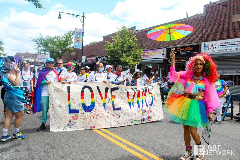 Marchers with a sign that says "Love Wins."