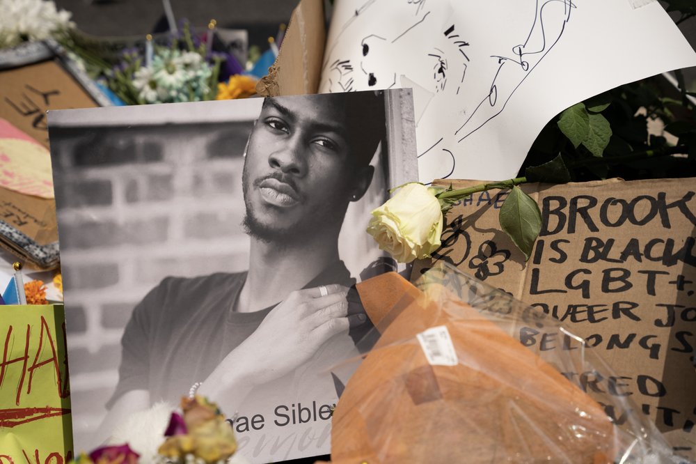 A memorial showing with flowers and a photo of a young man.