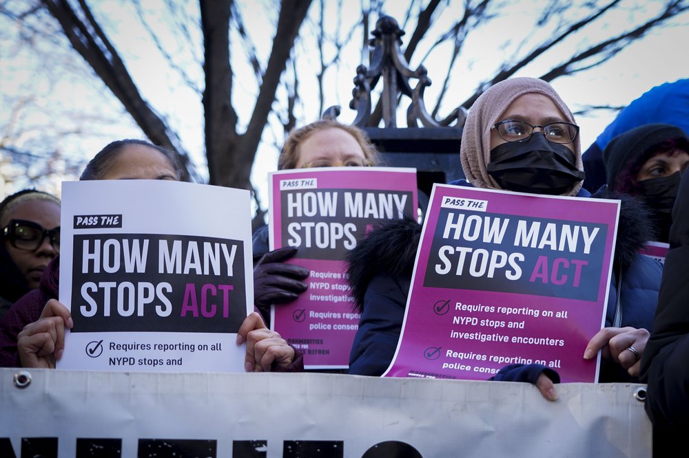 Signs at a December rally in favor of the How Many Stops Act.