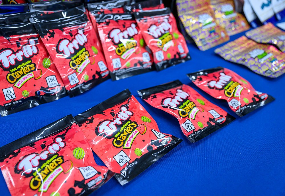 Marijuana gummies inside of bright red packaging similar to the sour gummy worm packages seen at stores.