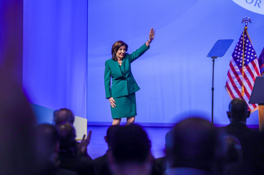 Kathy Hochul waves on stage.