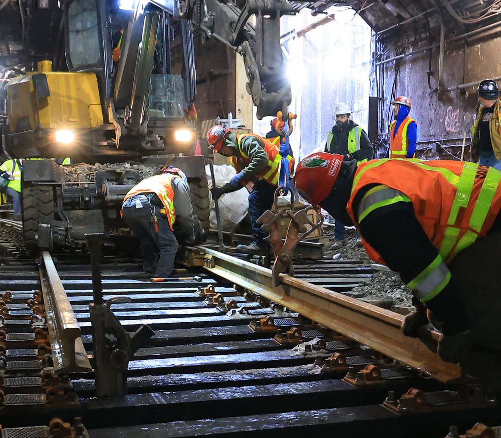 Workers carefully position new rail onto freshly installed ties and fasteners just outside the station tunnel, according to the Port Authority.