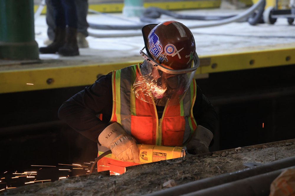 A worker installs a protective guard along the platform edge, adding an extra layer of reinforcement for the concrete surface, according to the Port Authority.