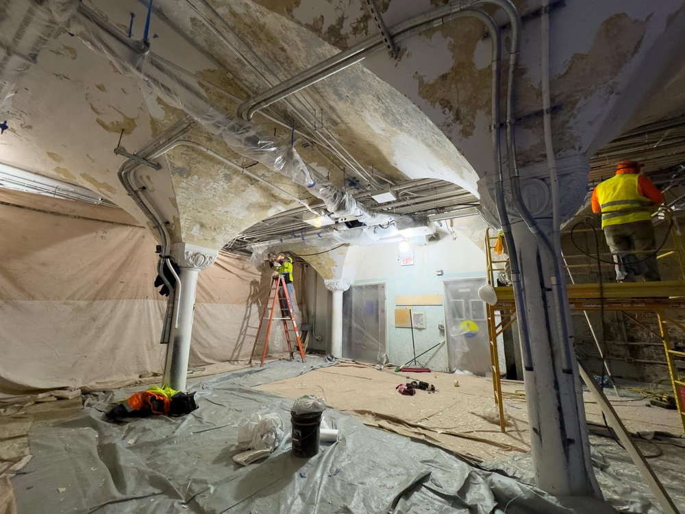 While the platform level already showcases the station’s new white and Lackawanna Green color scheme, crews are stripping old paint from the mezzanine’s ceiling and columns to prepare for a fresh coat.