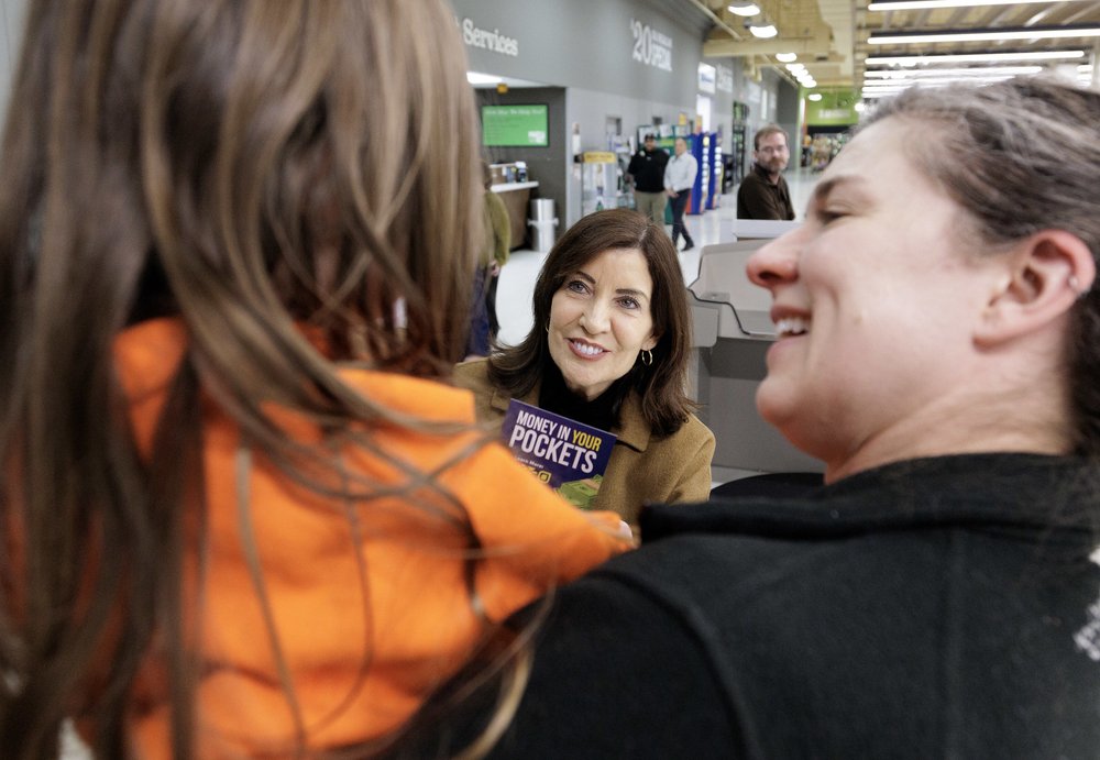 Gov. Kathy Hochul in a grocery store looking over people's shoulder