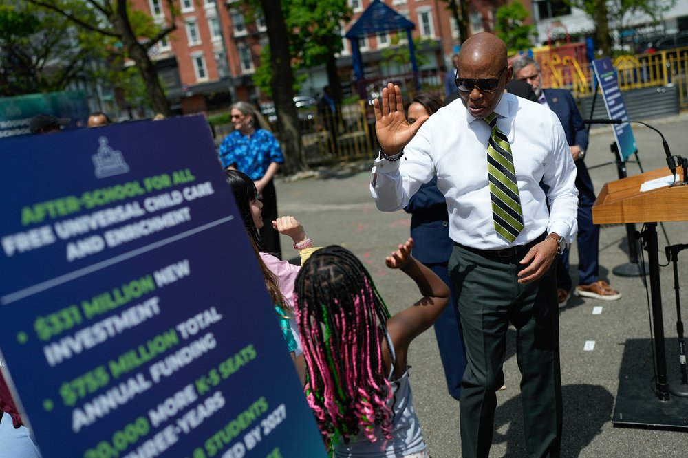 New York City Mayor Eric Adams high-fives a child