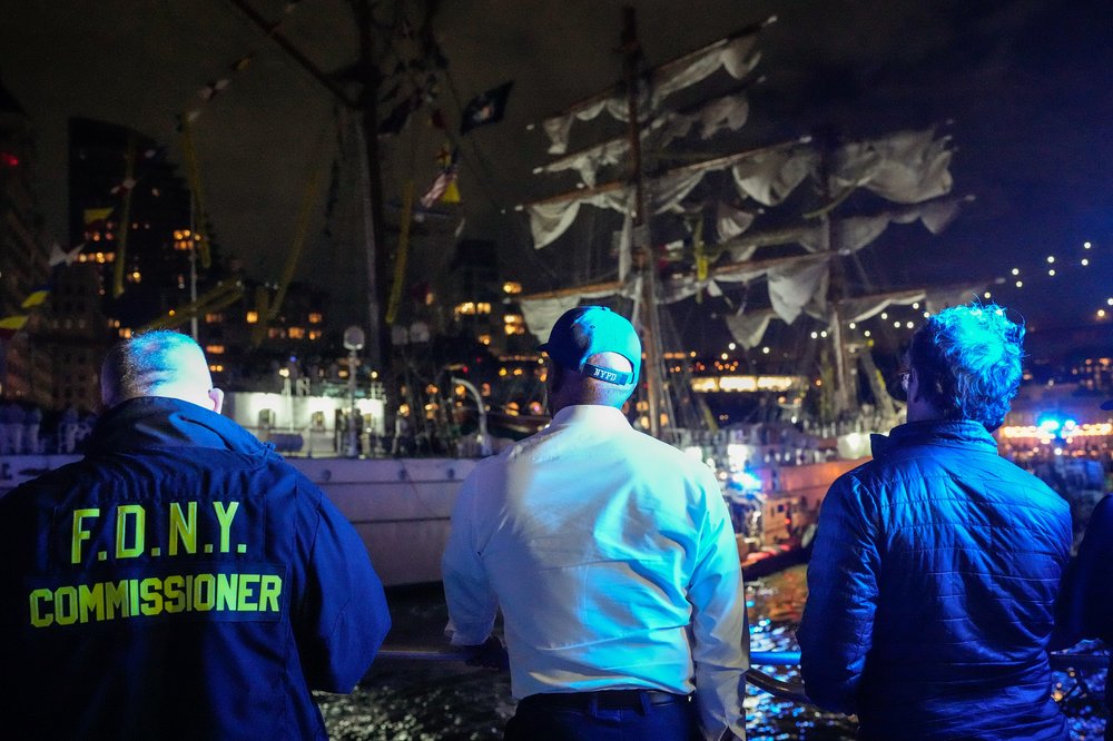 mayor adams and other officials looking at the boat.