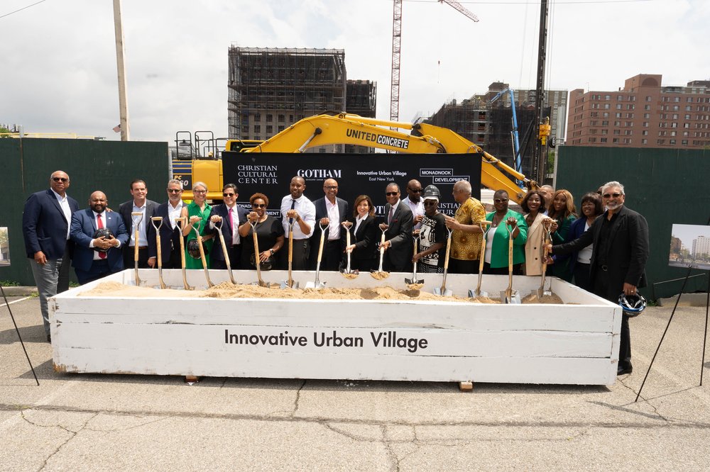 Several officials hold shovels to break ground on the Innovative Urban Village