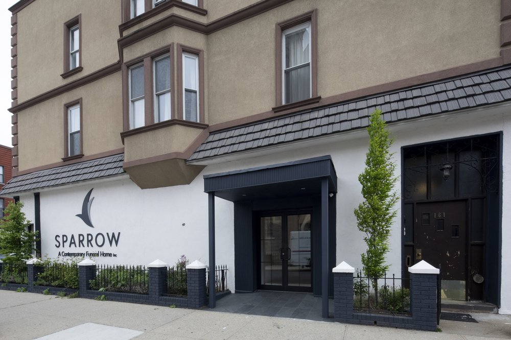 The facade of a building. "Sparrow: a contemporary funeral home" is written on the wall.