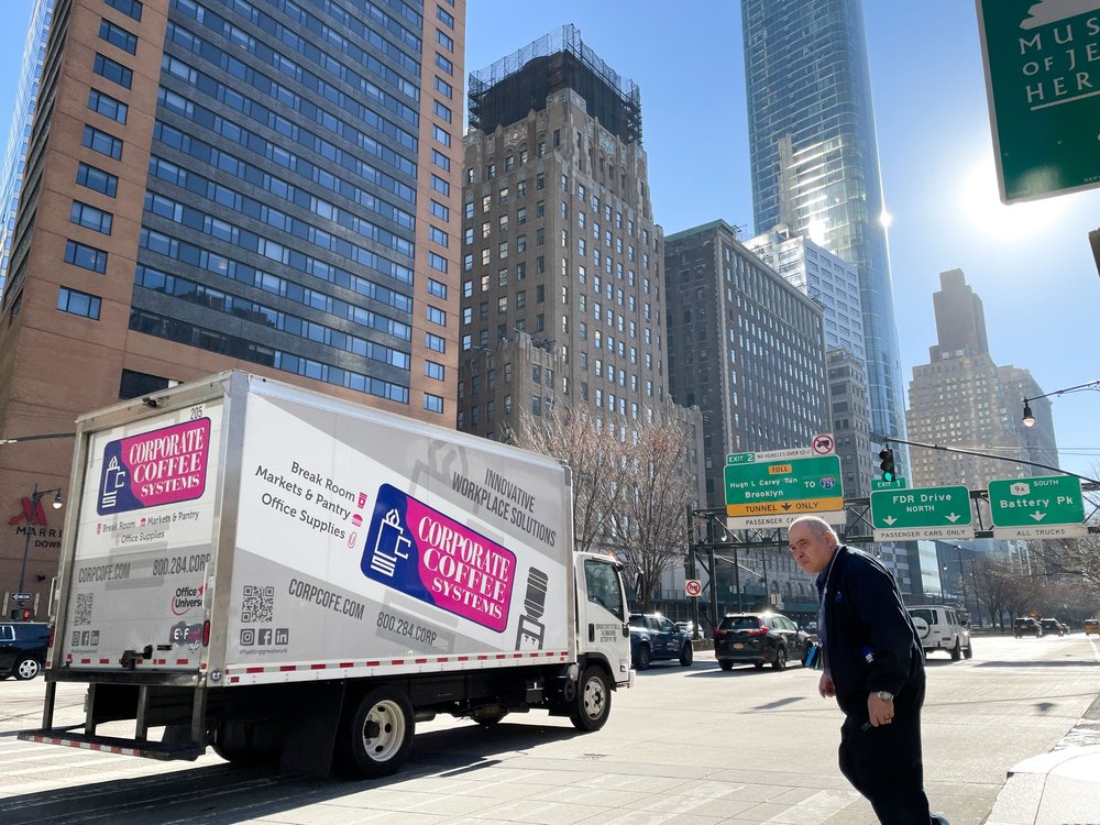 A man crossing a busy Manhattan street.