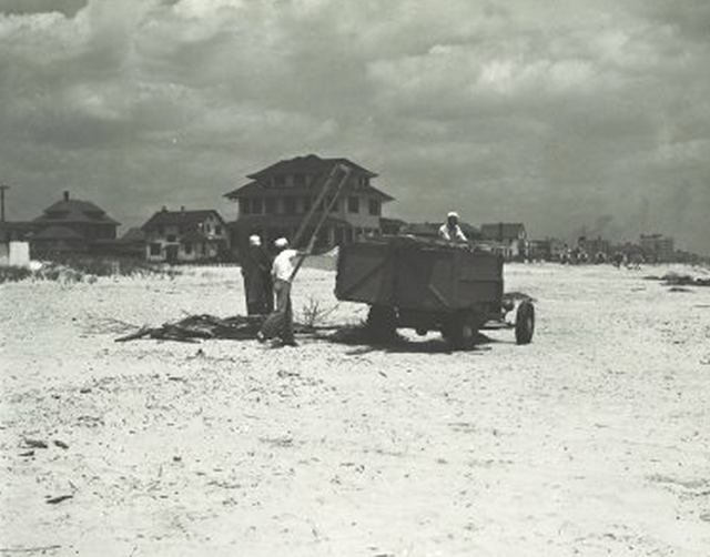 5NEWOLDROCK05.jpeg "Rockaway Beach, Queens. Crew picking up debris and throwing it into small truck. Houses in background. June 23, 1942."