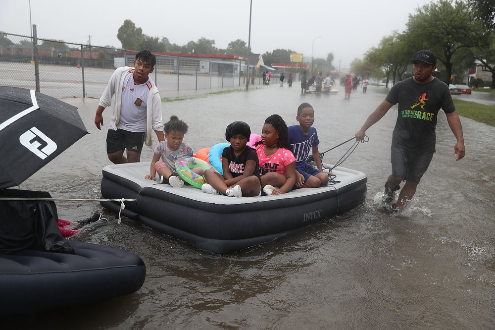 60cbd52f9gettyimages-839968512-jpg.jpeg People use an air matress to float down a flooded street as they evacuate their homes after the area was inundated with flooding from Hurricane Harvey on August 27, 2017 in Houston, Texas<br>