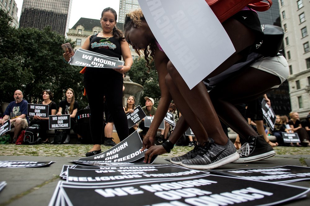 6d2f3df47081317trumptowerprotest-2-jpg.jpeg In New York on vacation from Tulsa, Oklahoma, Regina Loftin picks out a sign to hold during Monday evening's protests outside of Trump Tower. "We need a change," Loftin said.<br>