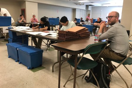 Workers inside the Rentar Plaza mall sort Queens DA ballots into accordion folders