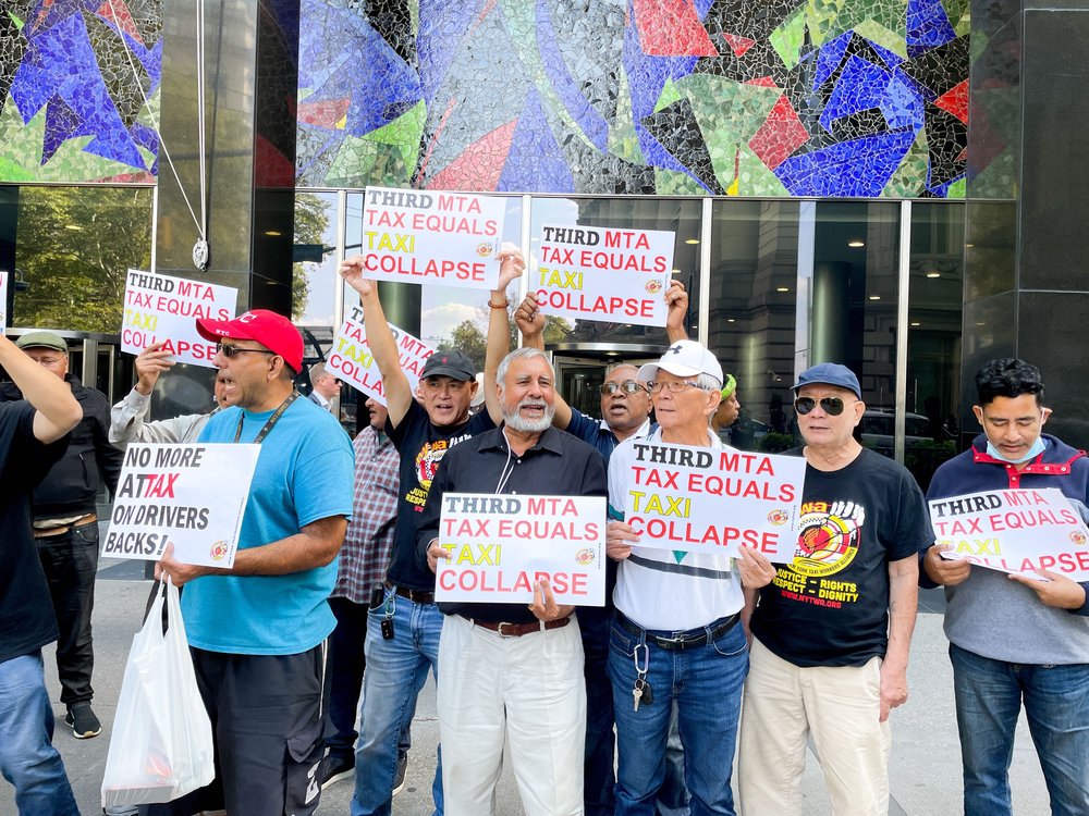 Outside of the MTA headquarters in Lower Manhattan, yellow cab drivers holding signs protest ahead of the meeting.