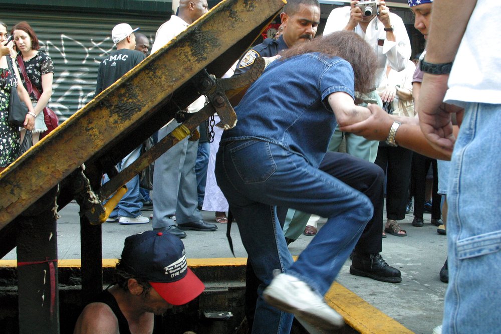 People being helped out of sidewalk subway exits on August 14, 2003 (Shutterstock)