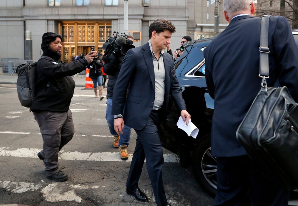 7eb76bc22shutterstock_10152380b-jpg.jpeg Gordon Caplan of Greenwich, Conn., center, walks out of federal court, in New York. Caplan, who is co-chairman of the international law firm Willkie Farr & Gallagher, was accused of paying $75,000 to get a test supervisor to correct the answers on his daughter's ACT exam after she took it. (Julie Jacobson/AP/Shutterstock)