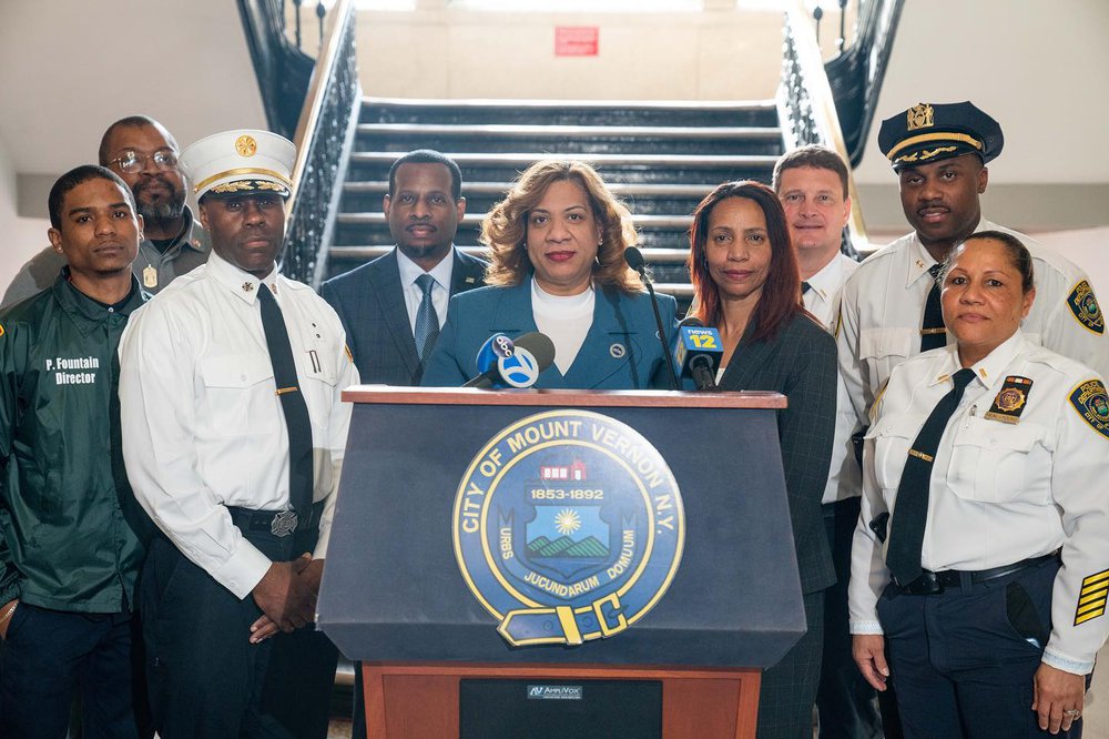 This year Mount Vernon’s new mayor Shawyn Patterson-Howard (center, at podium) appointed a new police commissioner, who put several former narcotics officers under investigation following Gothamist/WNYC's investigations. Commissioner Glenn Scott stands behind the mayor in a dark suit and blue tie.