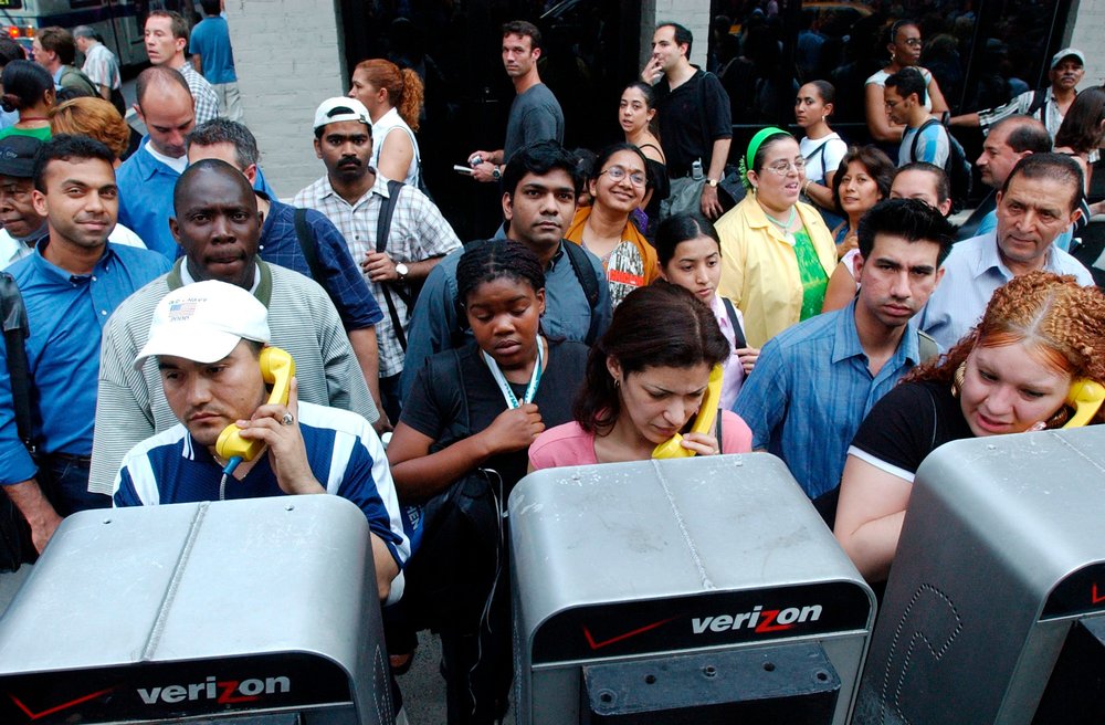 People gather to make payphone calls on August 14, 2003 (the cellphone towers were jammed!) (FRANK FRANKLIN II/AP/Shutterstock)