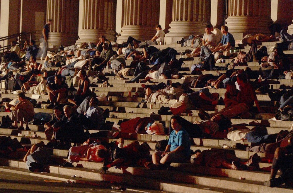 Commuters sleep on the steps of the Farley post office on August 14, 2003 (MIKE APPLETON/AP/Shutterstock)