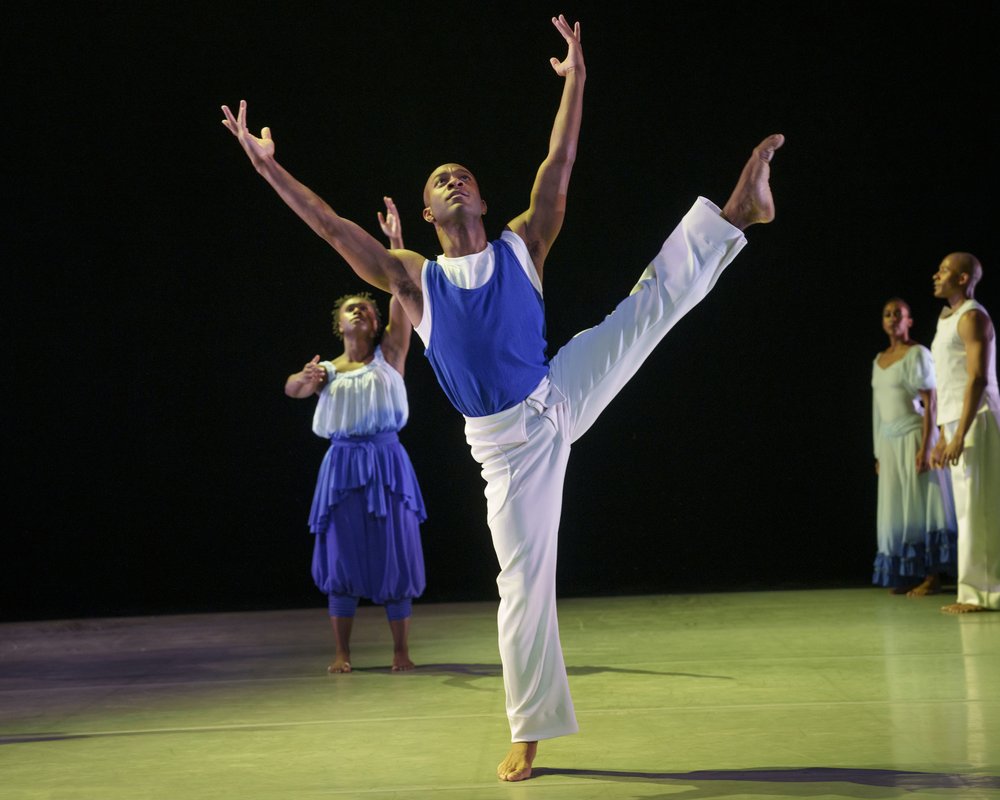 A dancer kicks up his leg.