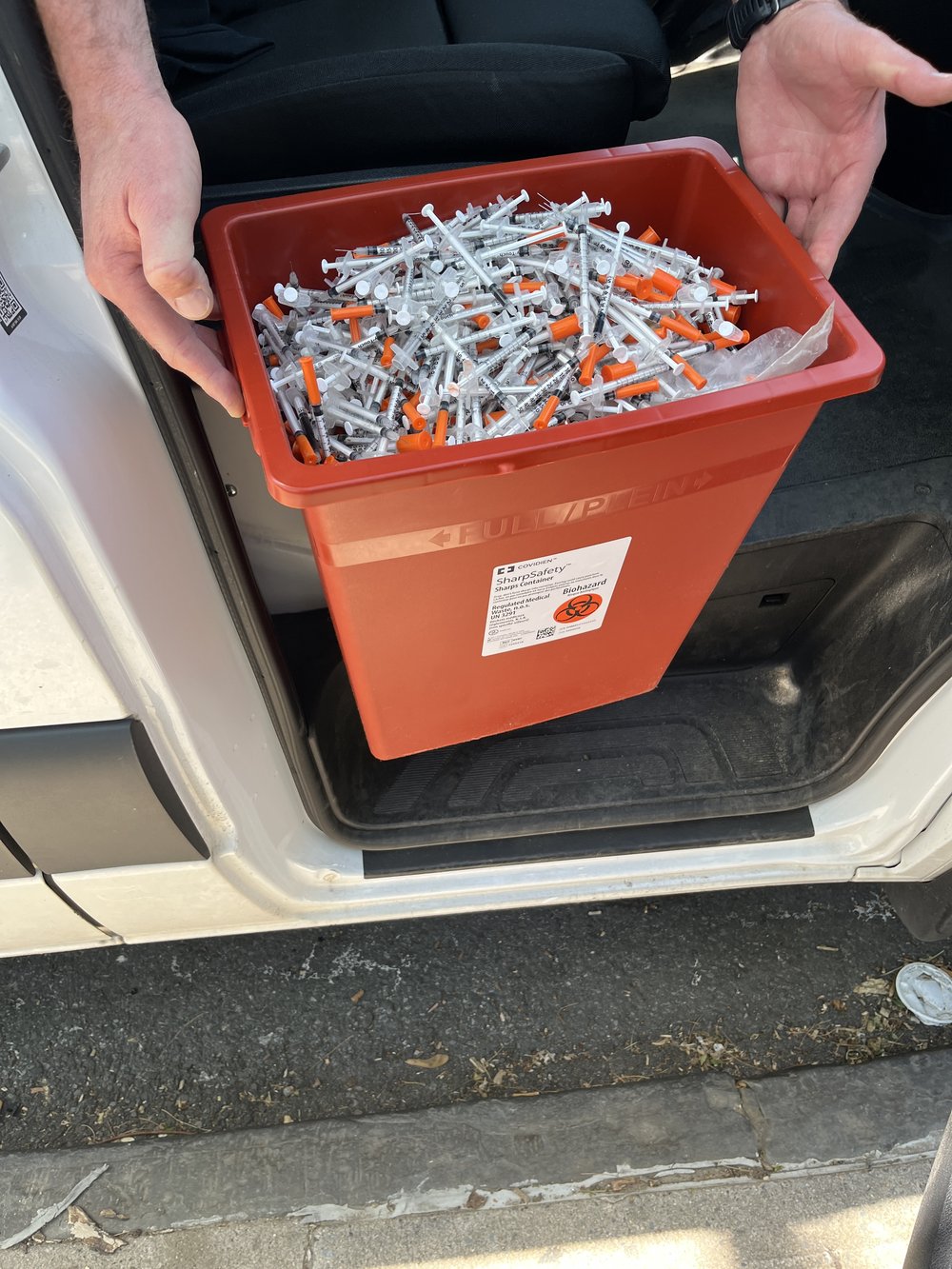 A collection basket brimming with used needles.