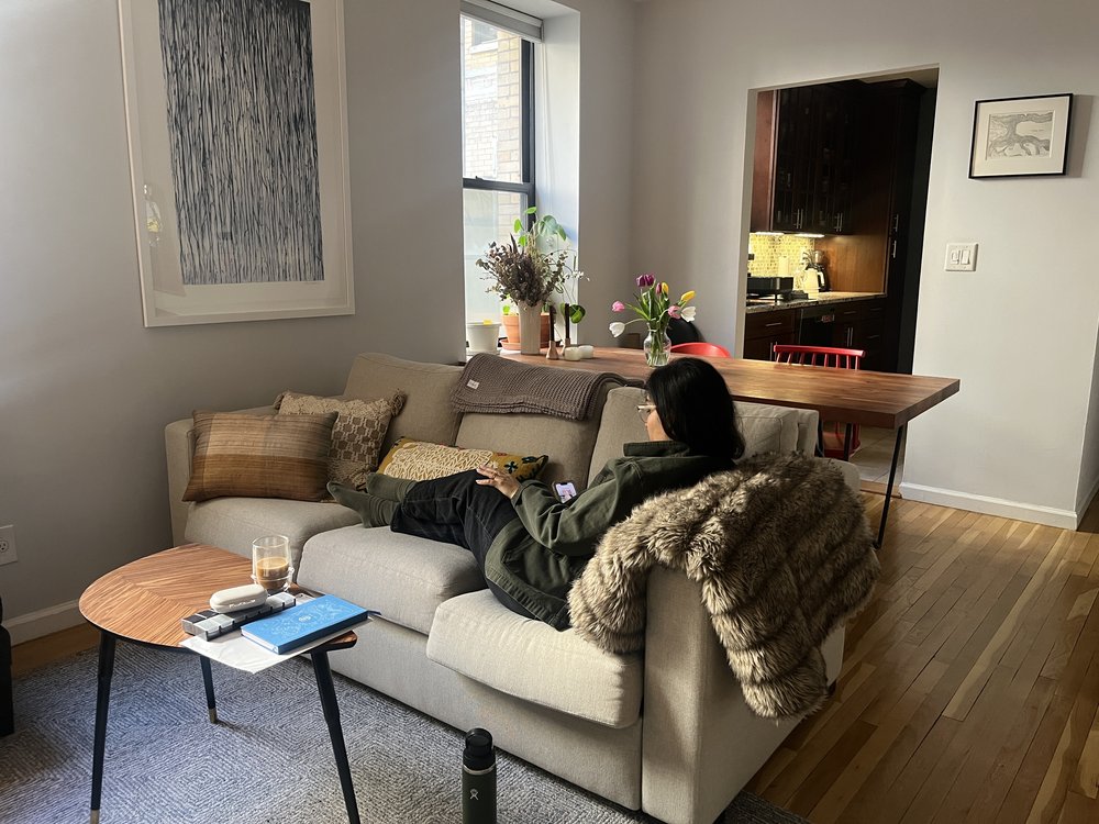 Alisha reclining on her couch at home.