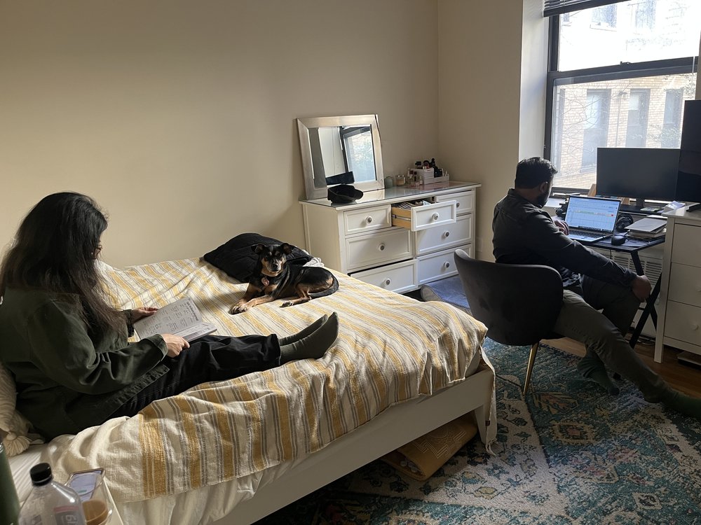 Alisha with her husband and dog at home in Brooklyn. Because of chronic fatigue associated with long COVID she has to spend much of the day reclining.