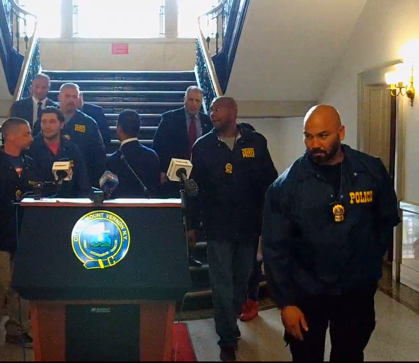 Detective Camilo Antonini (right foreground) leaving a press conference held by Mount Vernon’s former mayor and police commissioner.