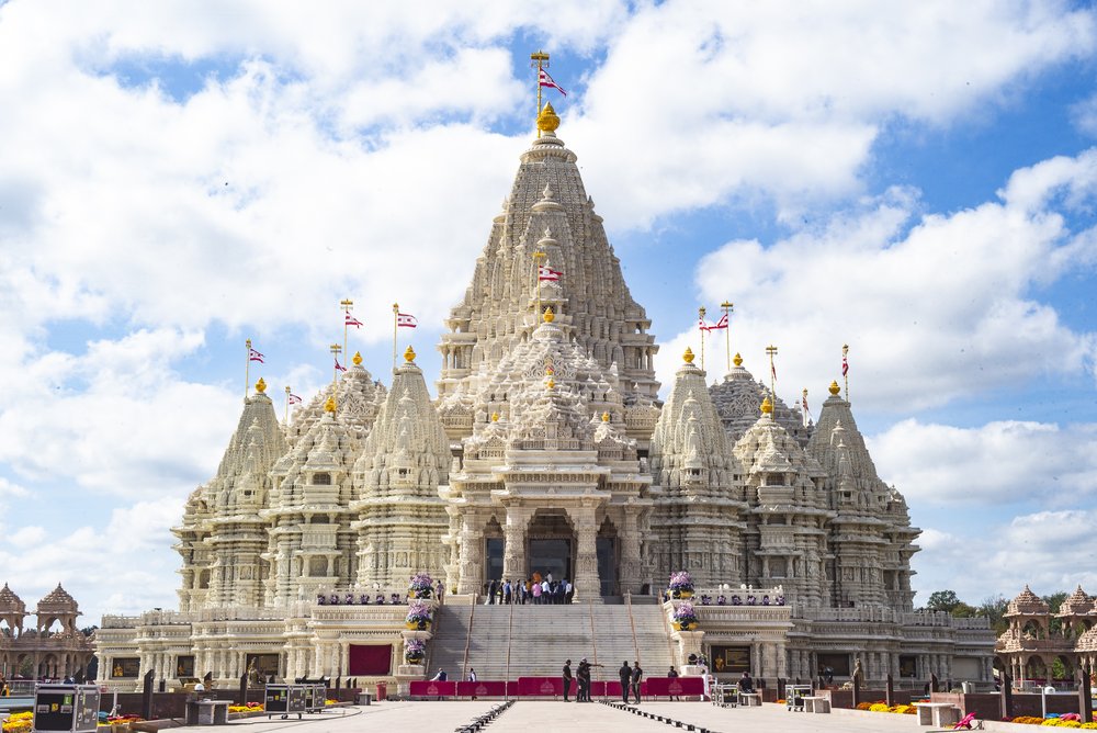 A large, white, and intricately designed structure sits at the end of a walkway.