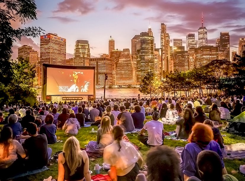 A group of people watch a movie outside.