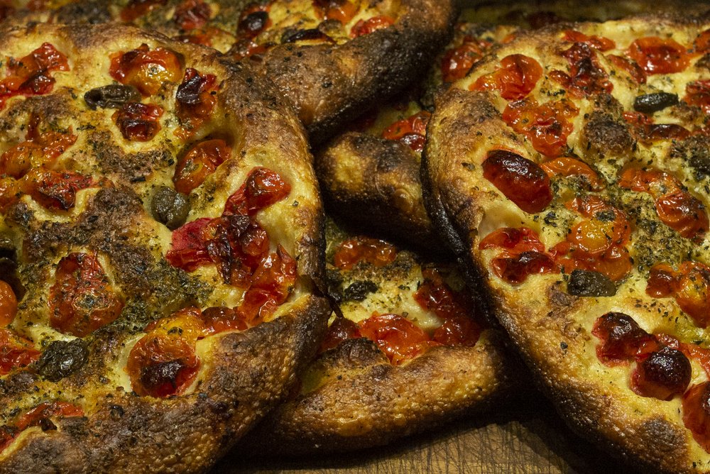 stacks of cheese pizza with tomatoes
